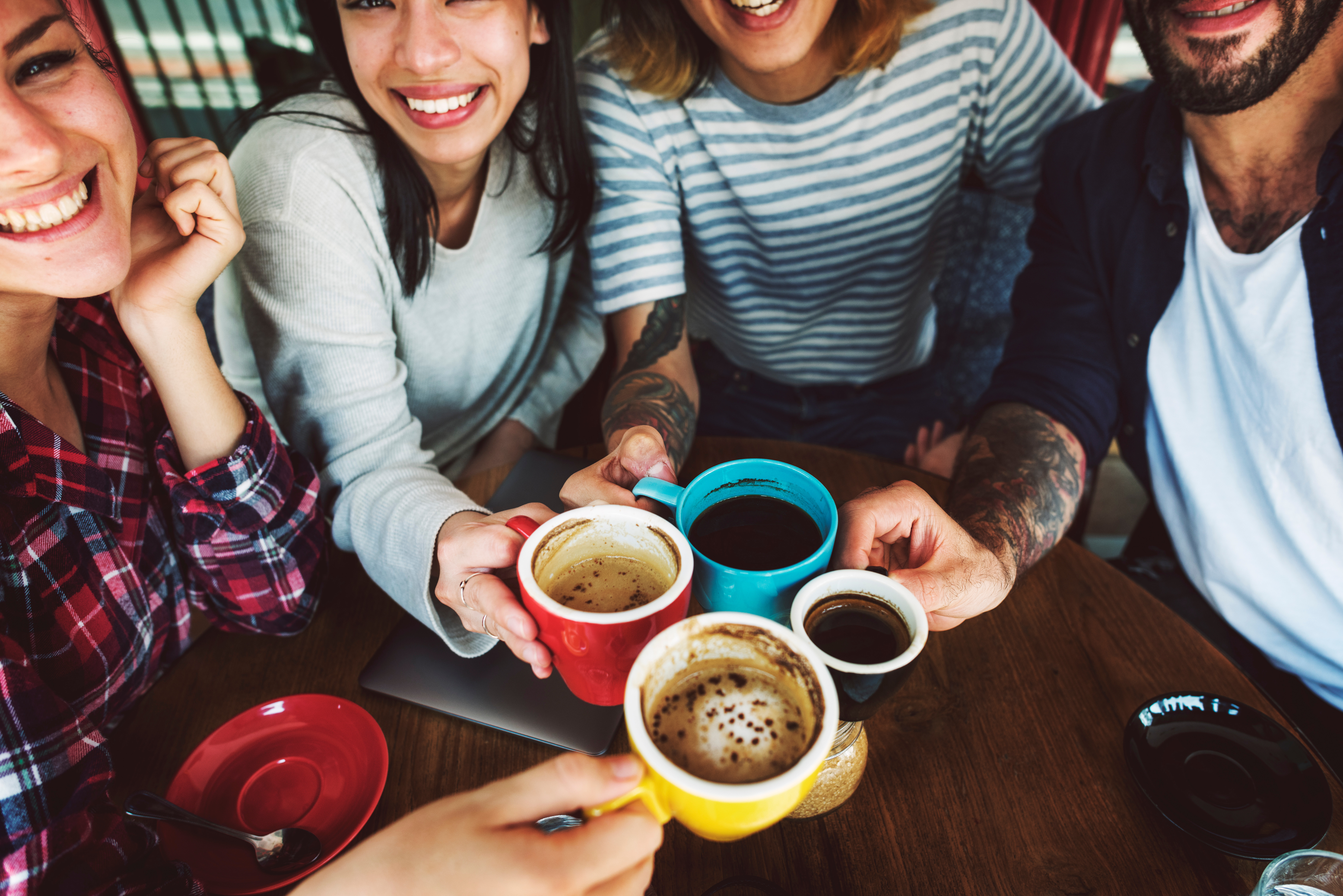 Freunde stoßen mit Kaffee an